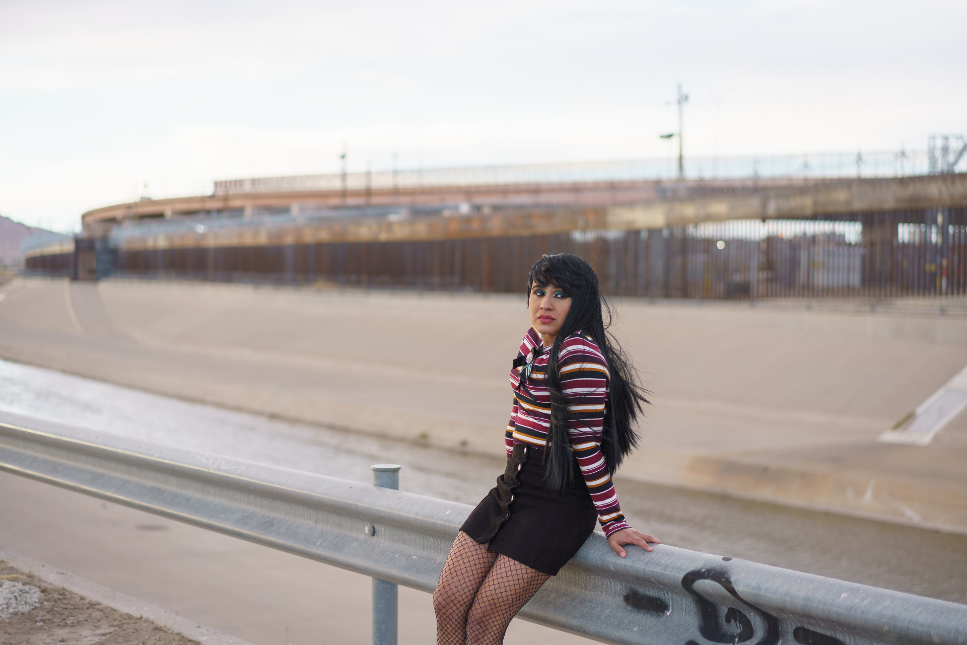 Fernanda stands by a rail at the US-Mexico border