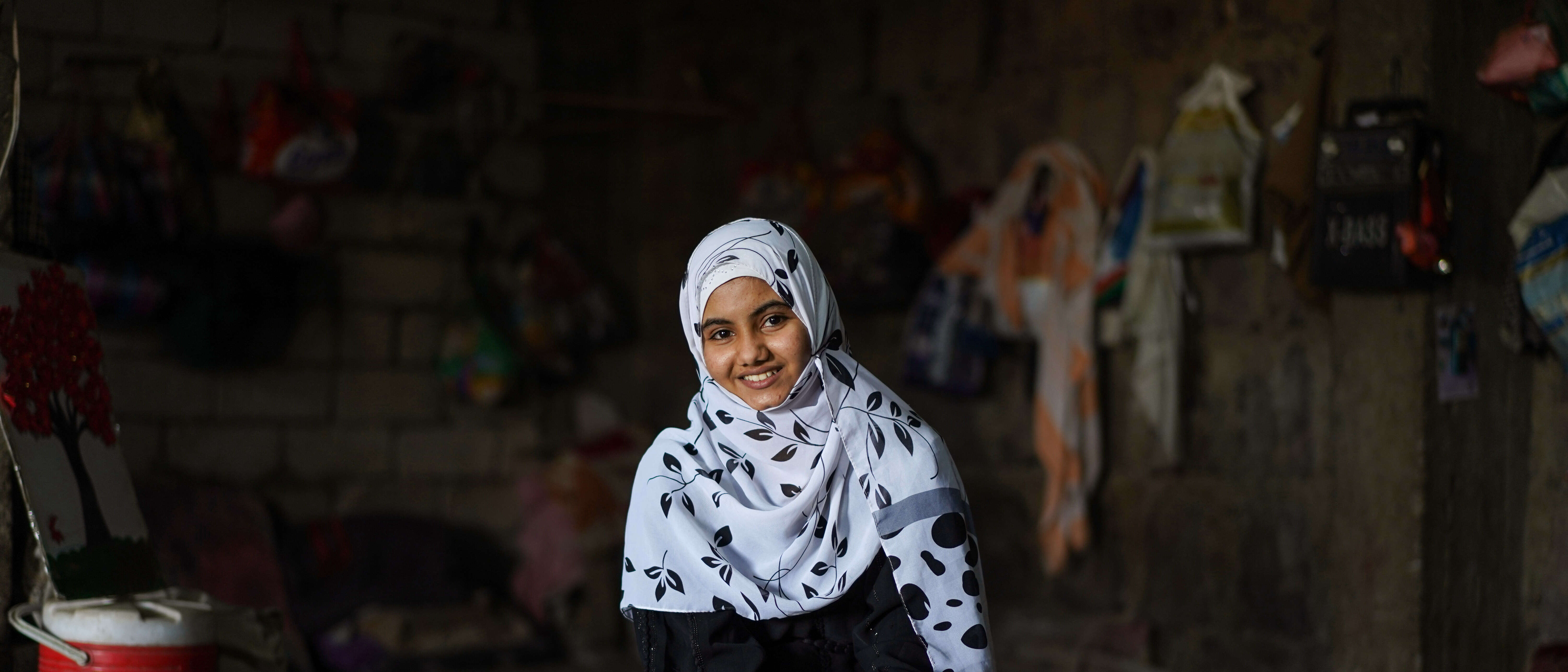 A girl poses for a portrait and smiles at the camera.