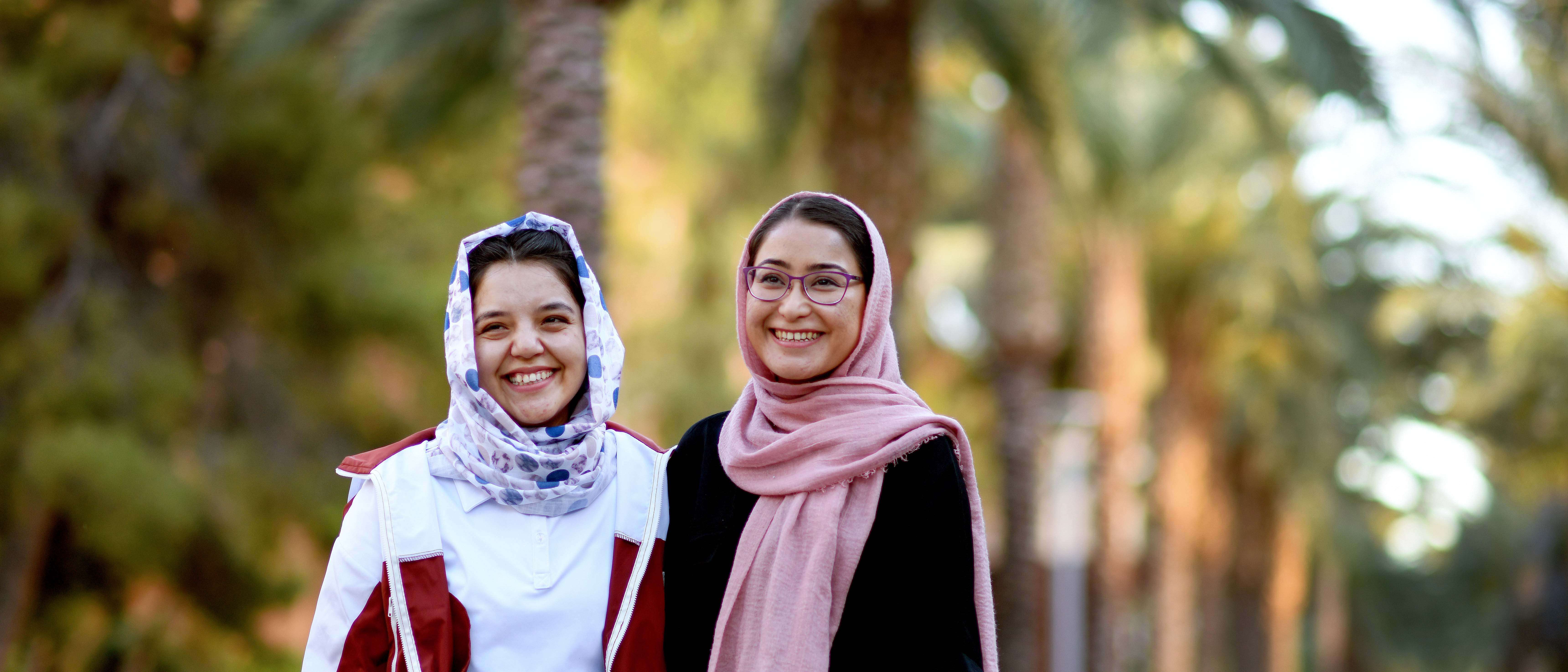 Two young women smile together and pose for a photo.